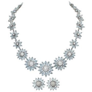 Signed "Asprey" London, Daisy Heritage collection, brilliant cut blue topaz and diamonds necklace and earrings parure, set  in 18k white gold.